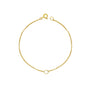 A gold bracelet with a small circle detail, displayed against a white background.
