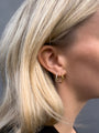Model wearing a sterling silver and an 18k gold vermeil endless hoop.