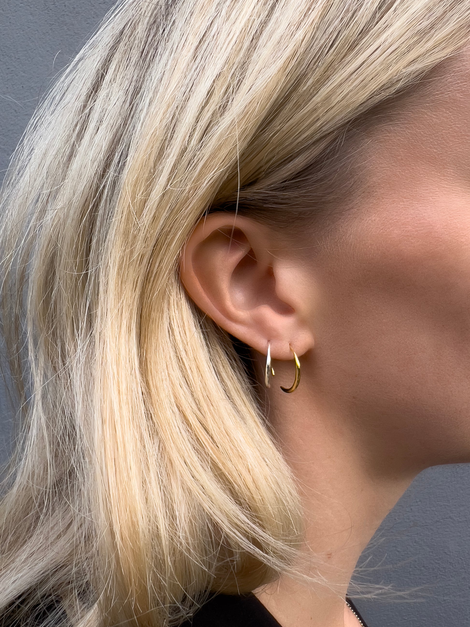 Model wearing a sterling silver and an 18k gold vermeil endless hoop.