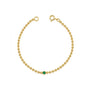 Gold ball chain bracelet with a green emerald on a white background