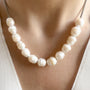 White freshwater pearl necklace being worn on a person's neck