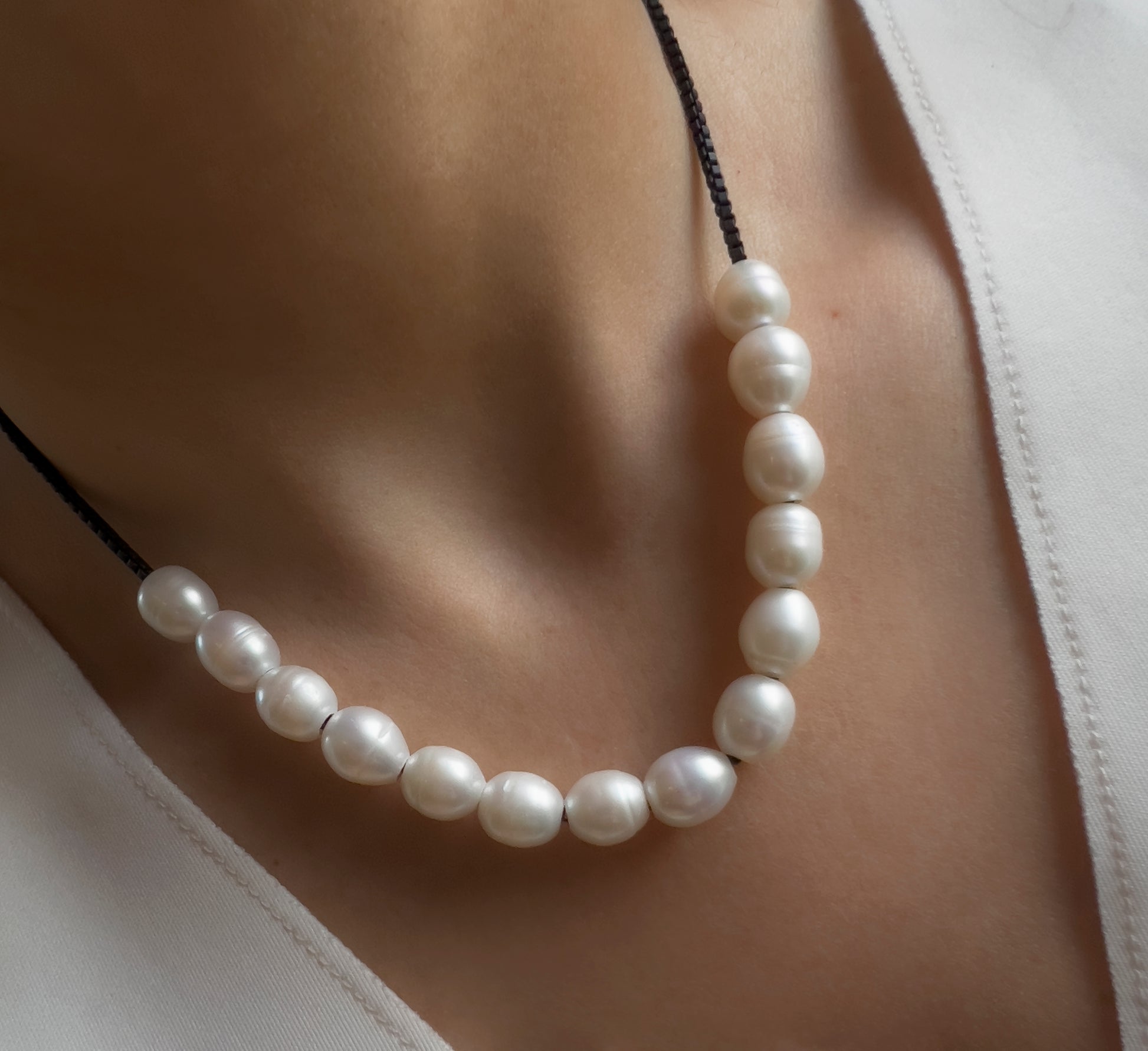 White large pearl necklace on black chain