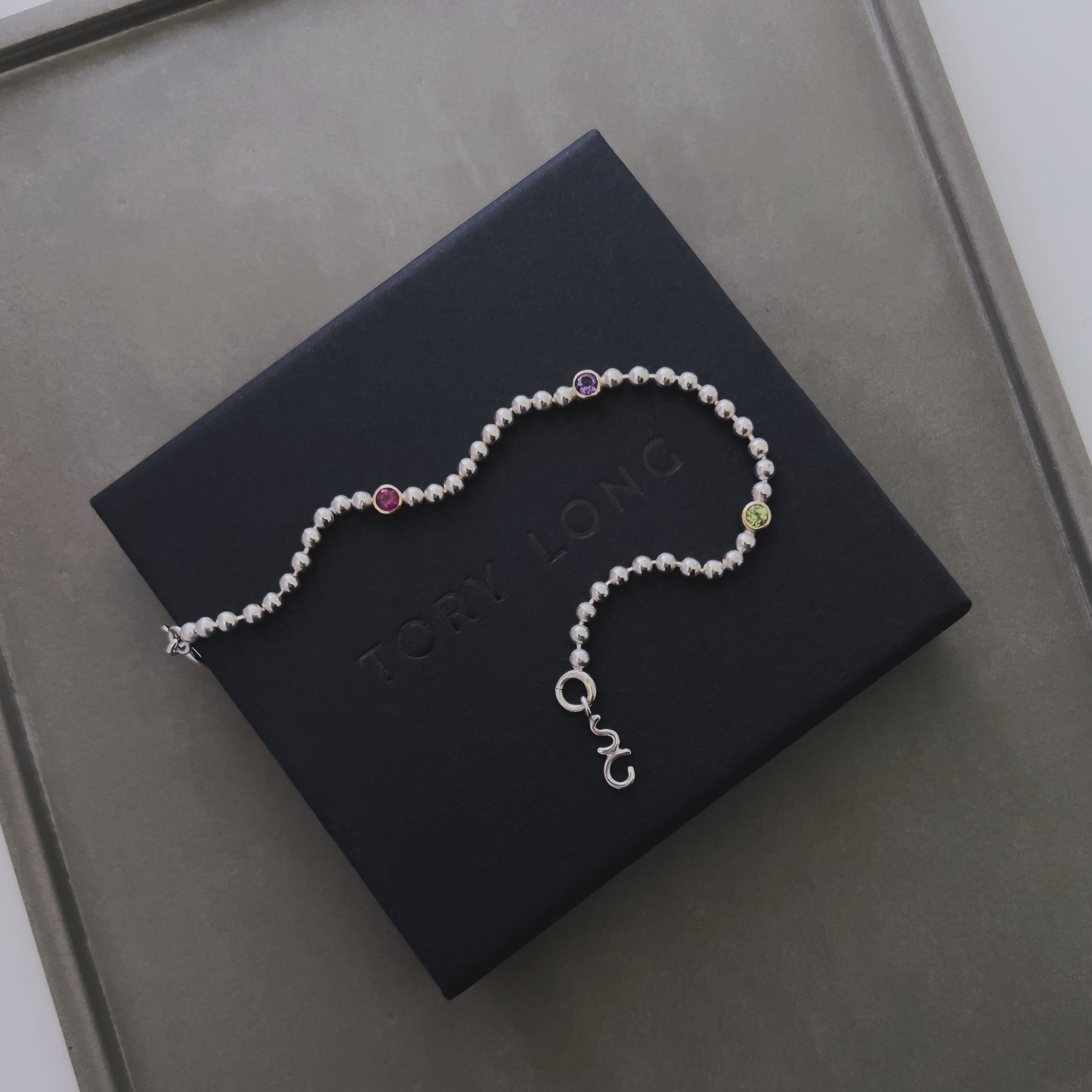 silver ball chain bracelet with three birthstones, ruby, amethyst, peridot