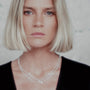 Woman wearing a silver spike necklace with a neutral background